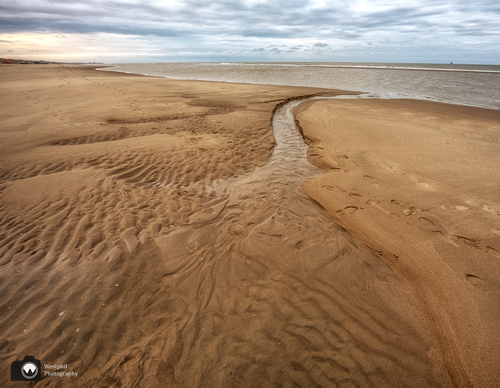Water slingert door het strand