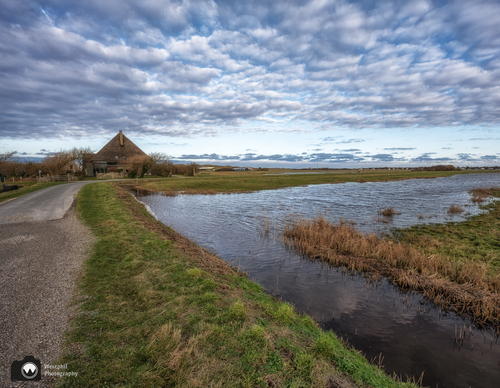 Een overstroomde sloot in een bocht