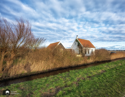 Wit huis aan een sloot