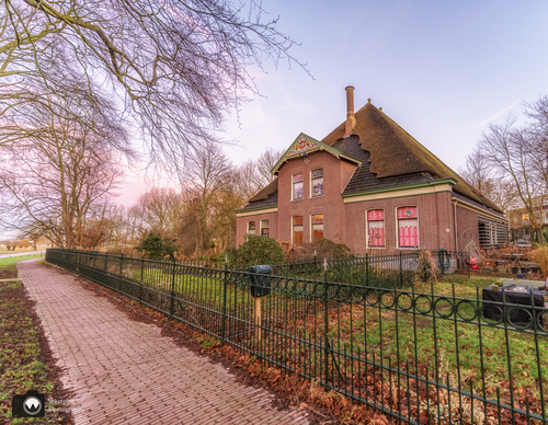 Grote boerderij achter gietijzeren hek