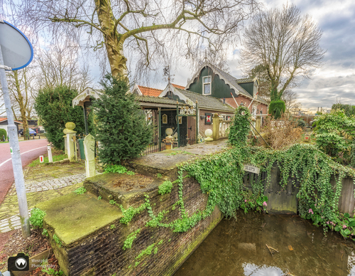 Groen hoekje in de gracht met ouderwets sluisje