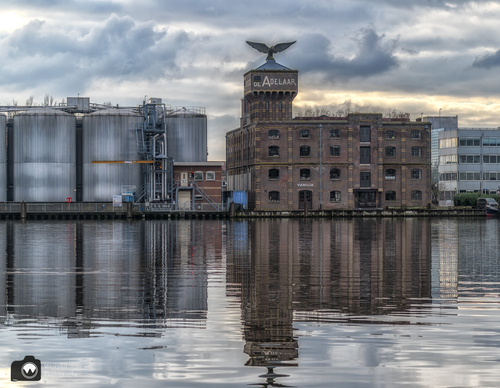 Grote fabriek aan het water met adelaar op het dak