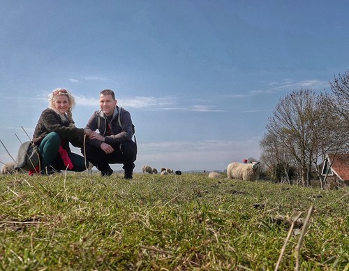 Man en vrouw hurken voor de camera in het gras