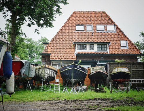 Boerderij met rij boten op het drogr