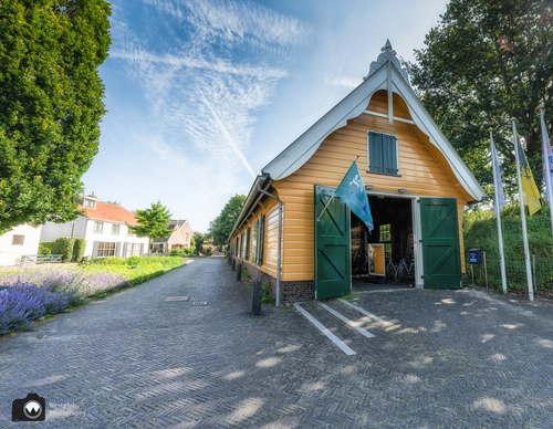 Geel geverfde loods met groene luiken