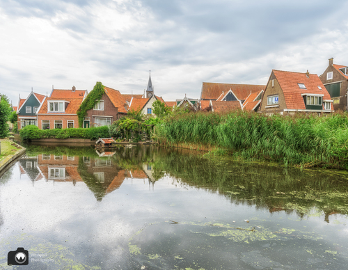 Eendenvijver met huizen aan de rand