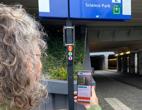 Bregje met telefoon bij startpunt wandeling