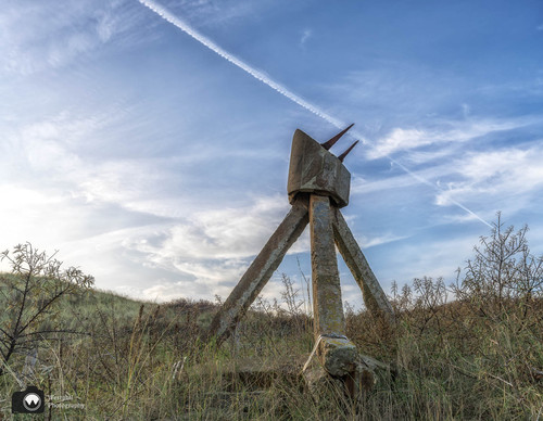 laura op de rug gezien met open armen in een duinpan