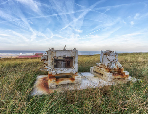 laura op de rug gezien met open armen in een duinpan