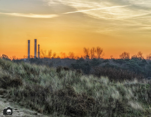 rode lucht met fabriek in de verte