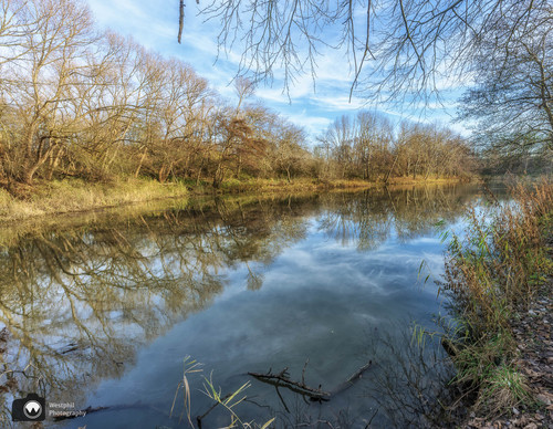 laura op de rug gezien met open armen in een duinpan