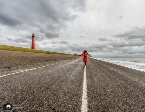 laura op de dijk met armen wijd en vuurtoren