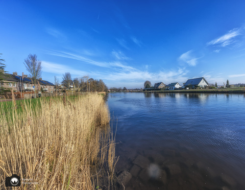 Groot kanaal met huizen aan de overkant