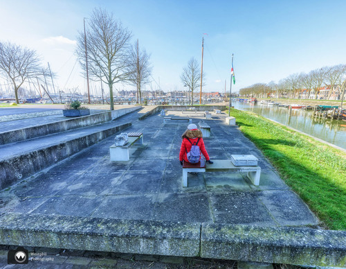 Laura op stenen bankje bij haven