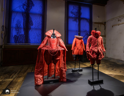 Groep rode kostuums tentoongesteld