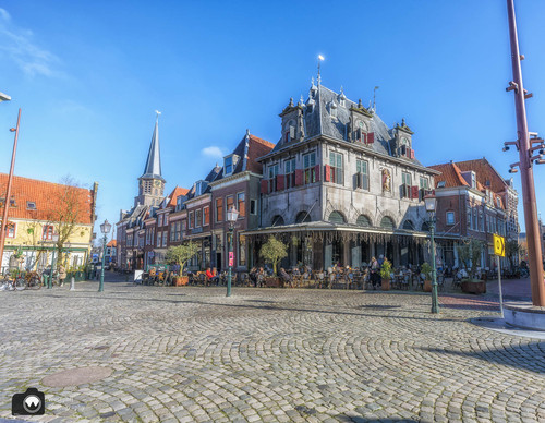 Plein met restaurant op de hoek en terras
