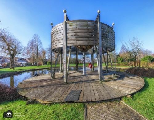 Laura zit onder houten kunstwerk