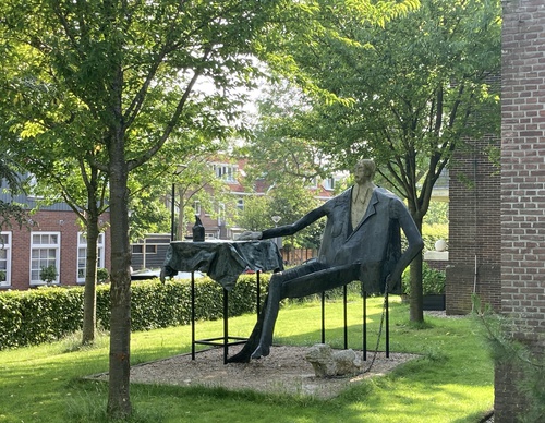 standbeeld van een dandy zittend aan een tafel